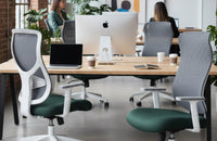 Sillas de oficina ergonómicas con respaldo de malla en un espacio de trabajo open space.